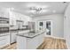 Modern kitchen features stainless steel appliances, a granite countertop island, and French doors to the patio at 223 Pinehurst Dr, Auburndale, FL 33823