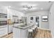 Bright kitchen featuring stainless appliances, white cabinets, and a large island with bar stool seating at 223 Pinehurst Dr, Auburndale, FL 33823
