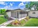 A screened-in porch surrounded by lush landscaping, offering a peaceful outdoor space at 223 Pinehurst Dr, Auburndale, FL 33823