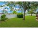 Spacious backyard featuring a large tree, lush green lawn, and a white privacy fence at 2973 Blackwater Creek Dr, Lakeland, FL 33810