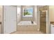 Bright bathroom featuring jacuzzi tub, walk in shower, granite top vanity and window at 2973 Blackwater Creek Dr, Lakeland, FL 33810