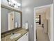 Bathroom featuring granite countertop, wood framed mirror, and access to adjacent room at 2973 Blackwater Creek Dr, Lakeland, FL 33810