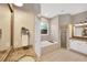 Luxurious bathroom featuring a soaking tub, separate shower, dual vanities, and elegant tile work at 2973 Blackwater Creek Dr, Lakeland, FL 33810