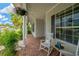 Charming covered front porch with brick flooring, decorated with potted plants and rocking chairs at 2973 Blackwater Creek Dr, Lakeland, FL 33810