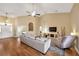 Comfortable living room featuring hardwood floors, a ceiling fan, and a cozy fireplace with television at 2973 Blackwater Creek Dr, Lakeland, FL 33810