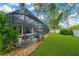 Screened-in pool area with outdoor seating, landscaping, and lush green lawn at 2973 Blackwater Creek Dr, Lakeland, FL 33810