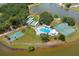 Community amenities including pool, tennis, and basketball courts set by pond in aerial view at 4209 Club Cir, Lakeshore, FL 33854