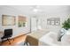 Bright bedroom with hardwood floors, a bed, a window, and a workspace with art pieces on the wall at 739 Park Hill Ave, Lakeland, FL 33801