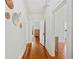 Long hallway with wood floors and white walls decorated with round woven decor at 739 Park Hill Ave, Lakeland, FL 33801