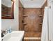 Bathroom shower featuring elegant brown tile, built-in shelves and bronze hardware at 739 Park Hill Ave, Lakeland, FL 33801