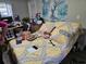 Bedroom featuring a large yellow and gray patterned bed and a blue tree wall hanging at 3220 Avenue J Nw, Winter Haven, FL 33881