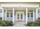 View of the house and porch with white columns, yellow accents, and brick walkway leading to the front door at 2401 Lafayette Ave, Winter Park, FL 32789