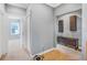 Hallway with carpet and blue-gray walls leading to a bedroom, and a cabinet for decorative display and storage at 2401 Lafayette Ave, Winter Park, FL 32789