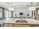 Kitchen island with granite countertops, stainless steel sink, and a view of the living room and backyard at 2401 Lafayette Ave, Winter Park, FL 32789