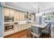 View of the kitchen with granite counters, island with stools, stainless appliances and hardwood floors at 2401 Lafayette Ave, Winter Park, FL 32789