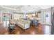 Open concept living room with hardwood floors, a large sectional couch, and a view of the kitchen at 2401 Lafayette Ave, Winter Park, FL 32789