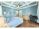 Comfortable main bedroom with a ceiling fan, blue walls, and hardwood flooring at 2401 Lafayette Ave, Winter Park, FL 32789