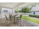 Covered outdoor patio with a stone paver floor and comfortable seating for al fresco dining and entertaining at 2401 Lafayette Ave, Winter Park, FL 32789