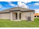 Exterior backyard view highlighting the covered patio, lawn and the home's exterior at 3228 Seville St, Lake Alfred, FL 33850