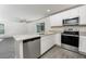 Modern kitchen features granite countertops, stainless steel appliances, and gray wood flooring at 3228 Seville St, Lake Alfred, FL 33850