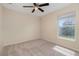 This bedroom has a ceiling fan, window, and soft, neutral carpet at 3243 Winchester Estates Cir, Lakeland, FL 33810