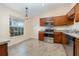 Bright kitchen with stainless steel appliances, wood cabinets, and a view from the large window at 3243 Winchester Estates Cir, Lakeland, FL 33810