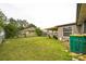View of the backyard featuring a covered patio and mature trees at 107 Talavera Ln, Kissimmee, FL 34758