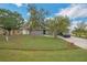 Traditional-style home featuring a well-manicured lawn and mature trees that create a welcoming curb appeal at 107 Talavera Ln, Kissimmee, FL 34758