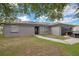 Charming single-story home featuring solar panels, a well-maintained lawn, and a black two-car garage at 107 Talavera Ln, Kissimmee, FL 34758