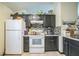 This kitchen features white appliances, black cabinets, a tiled backsplash, and plenty of counter space at 107 Talavera Ln, Kissimmee, FL 34758
