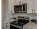 Close-up of stainless oven, microwave, and white cabinetry at 3763 King Hill Dr, Haines City, FL 33844