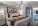 Beautifully staged main bedroom with luxurious bedding, a modern chandelier, and a view into the main bathroom at 3763 King Hill Dr, Haines City, FL 33844