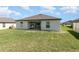 Well-maintained backyard with green grass, white fence, and outdoor patio area at 1741 Canaan Loop, Dundee, FL 33838