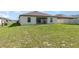 A spacious grassy backyard with a covered patio, ideal for enjoying outdoor activities and relaxation at 1741 Canaan Loop, Dundee, FL 33838