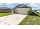 Lovely shot of a home's driveway and garage highlighting the landscaping and architecture at 1741 Canaan Loop, Dundee, FL 33838