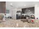 Modern kitchen with dark wood cabinets, granite countertops, and stainless steel appliances, flowing into dining area at 1741 Canaan Loop, Dundee, FL 33838