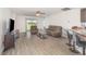 Cozy living room with gray laminate flooring, featuring access to backyard through sliding glass door at 1741 Canaan Loop, Dundee, FL 33838