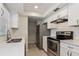 Kitchen featuring stainless steel appliances, white cabinetry and subway tile backsplash at 248 Lake Thomas Dr, Winter Haven, FL 33880