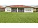 View of the house backyard with green grass and a screened patio at 448 Sorrento Rd, Kissimmee, FL 34759