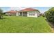 Expansive backyard with green grass, a screened patio, and well-maintained landscaping at 448 Sorrento Rd, Kissimmee, FL 34759