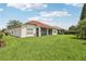 Expansive backyard with green grass, a screened patio, and well-maintained landscaping at 448 Sorrento Rd, Kissimmee, FL 34759