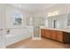 Bright bathroom featuring a tiled floor, soaking tub with large window, and glass enclosed shower at 448 Sorrento Rd, Kissimmee, FL 34759