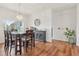 Dining area featuring hardwood floors, a stylish light fixture, and a large window overlooking the backyard at 448 Sorrento Rd, Kissimmee, FL 34759