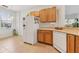 Functional kitchen area with tile flooring, white appliances, and wood cabinets at 448 Sorrento Rd, Kissimmee, FL 34759
