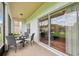 Enclosed lanai with tiled flooring, neutral furniture set, fan, and a clear view of the green back yard at 448 Sorrento Rd, Kissimmee, FL 34759