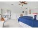 Bright main bedroom with carpet, ceiling fan, and sliding doors to the outdoor lanai with furniture and foliage at 448 Sorrento Rd, Kissimmee, FL 34759
