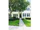Charming townhouse with black shutters, a lush green lawn, and a shade tree enhancing curb appeal at 5489 Baldwin Park St, Orlando, FL 32814