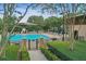 Community pool area featuring manicured landscaping, lounge chairs, and decorative architectural structures at 5489 Baldwin Park St, Orlando, FL 32814