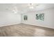 Bright bedroom with wood-look floors and two windows with ceiling fans at 5525 Tillman Rd, Lakeland, FL 33810