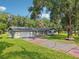 Single-story home with a gray exterior, driveway, and lawn with large tree at 5525 Tillman Rd, Lakeland, FL 33810